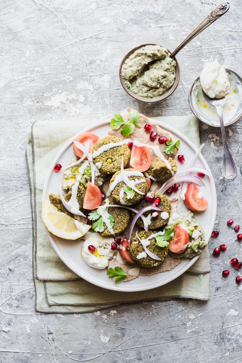 Piatto di falafel non fritti pronti per essere serviti con salsine e verdure