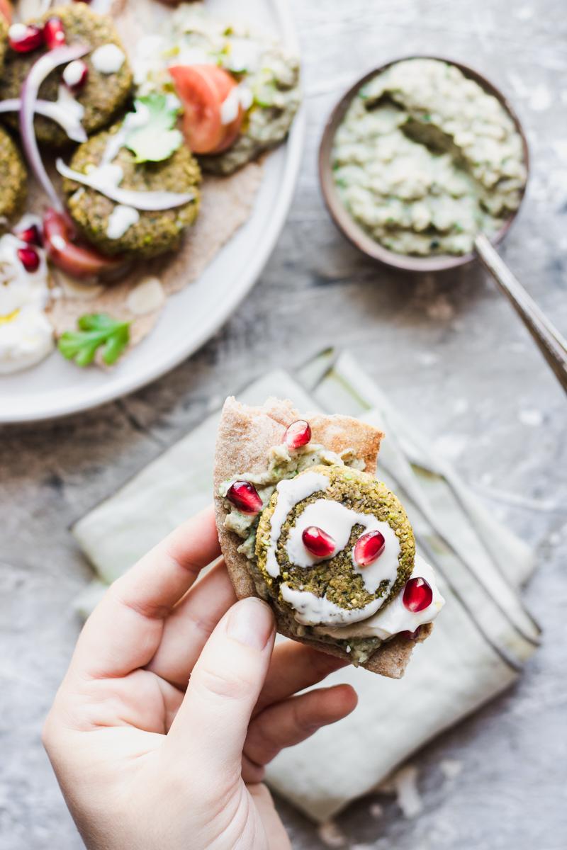 Un boccone di pane pita e falafel con salsine