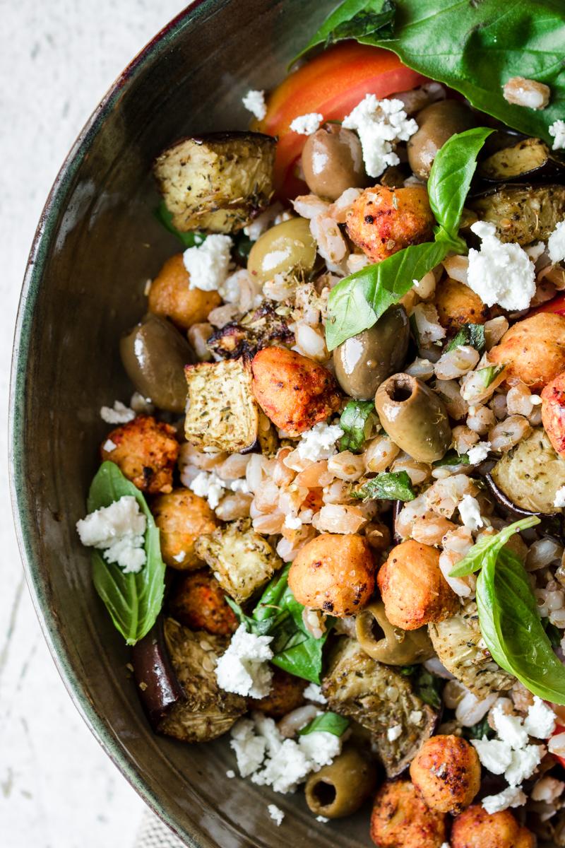 Close up di insalata di farro e ceci con melanzane, olive e basilico