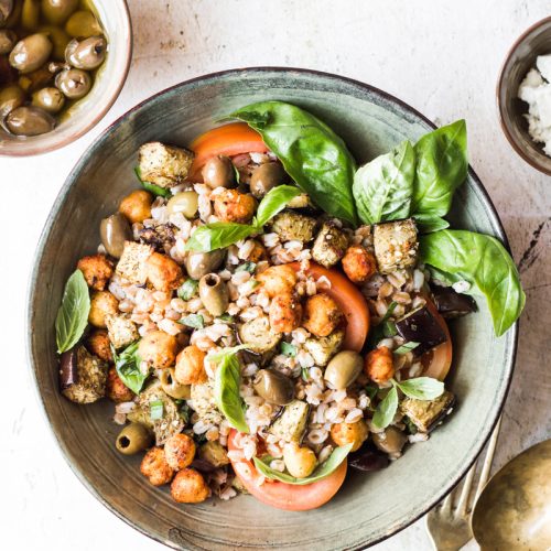 Ciotola con insalata di farro e ceci con basilico e pomodori