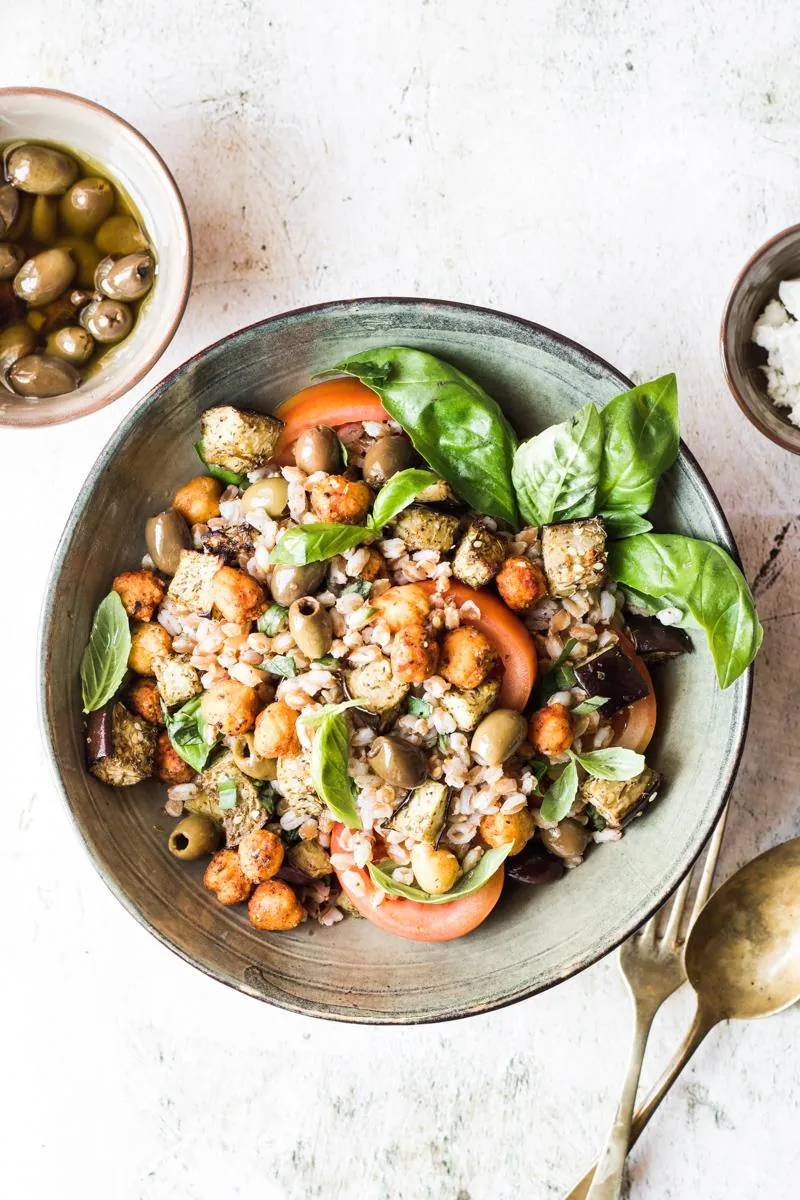 Ciotola con insalata di farro e ceci con basilico e pomodori