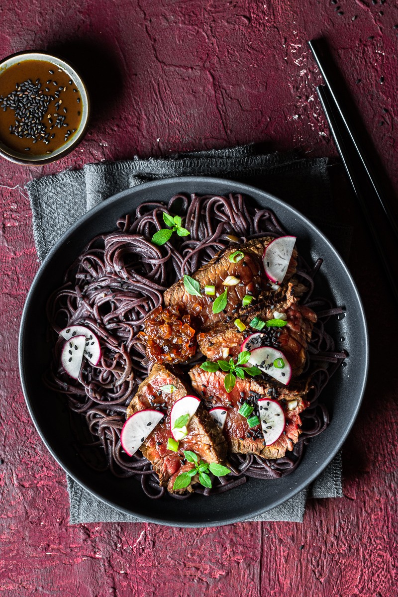 ciotola con noodle di riso nero e tataki di manzo