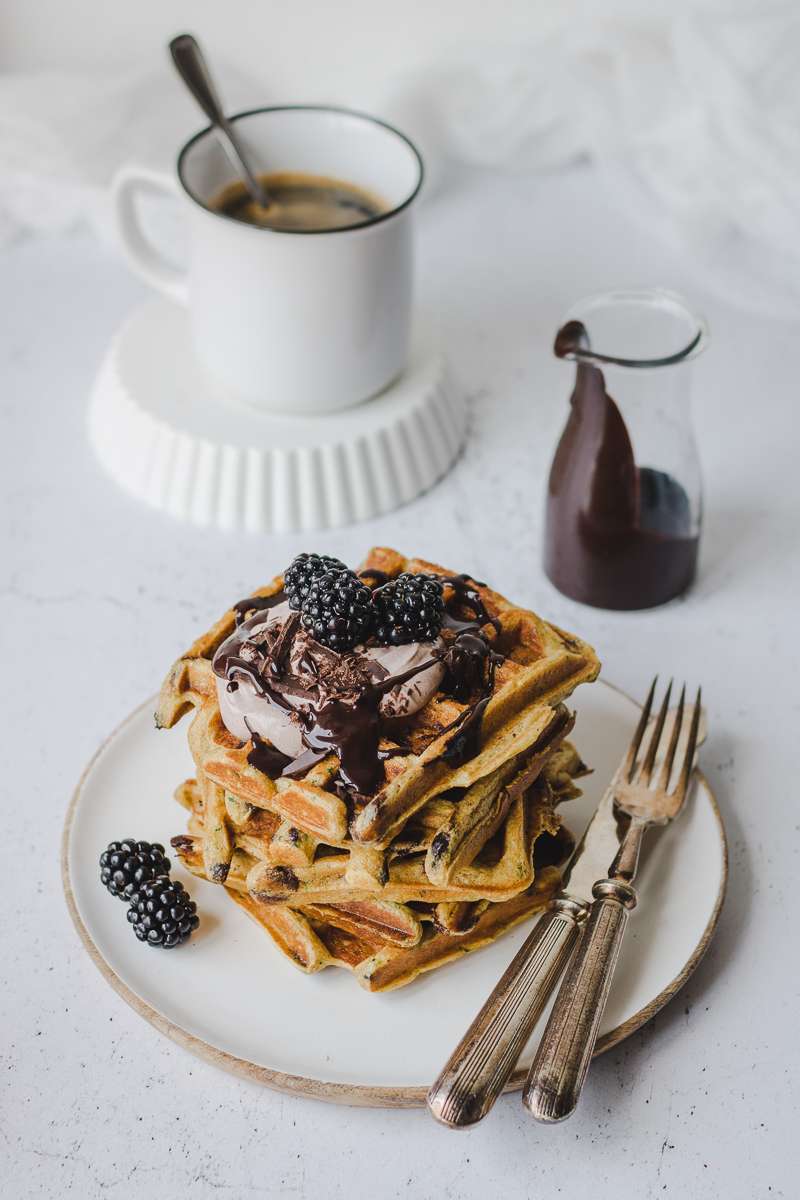 Pila di waffle di zucchine iperproteici al cioccolato con more