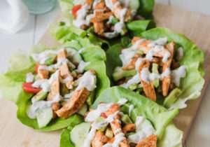Wrap di lattuga con pollo, insalata di cetrioli e pomodori, avocado e salsa greca, low carb