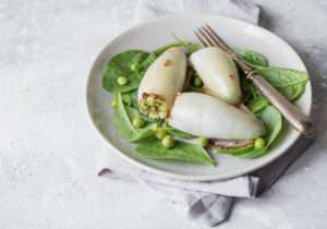 Calamari ripieni di piselli e orzo su letto di spinaci freschi