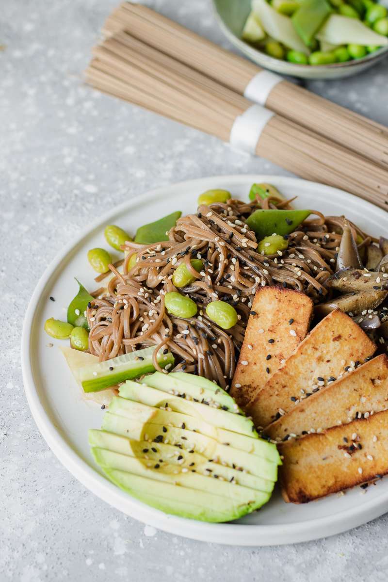 Insalata di soba fredda con salsa alla tahina, tofu affumicato, melanzane e avocado