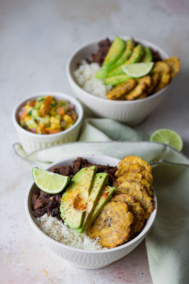 Bowl cubana vegana con avocado, fagioli neri, salsa al mango e tostones al forno