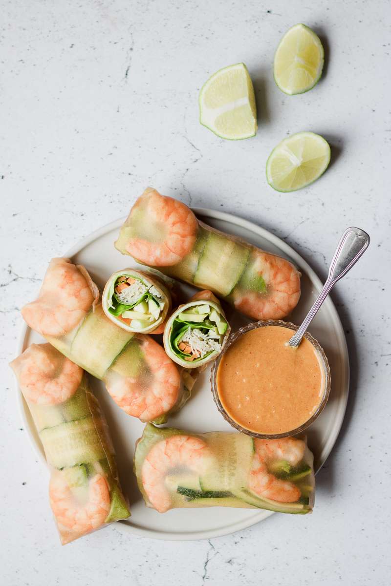 piatto di involtini vietnamiti di carta di riso integrale, con gamberi e verdura e salsa al burro di arachidi e mango, senza glutine e senza latticini