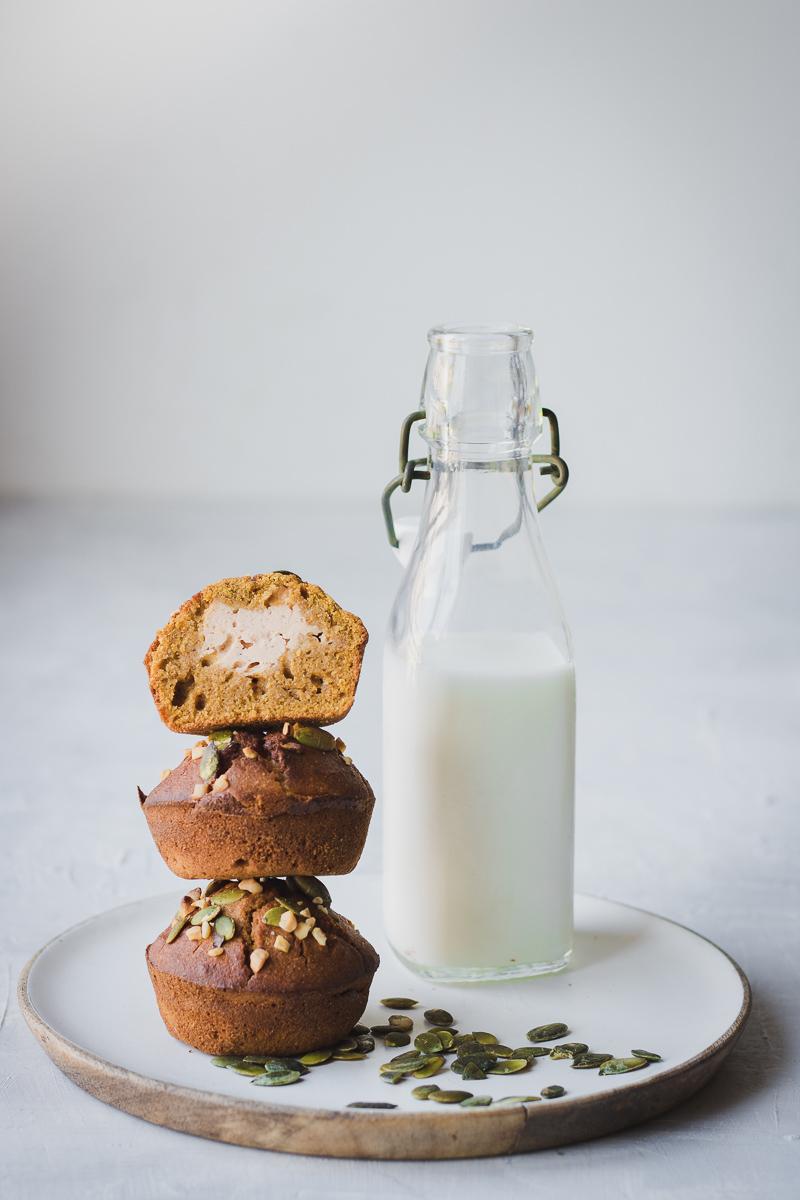 Pila di muffin alla zucca ripieni di cream cheese , con bottiglietta di latte