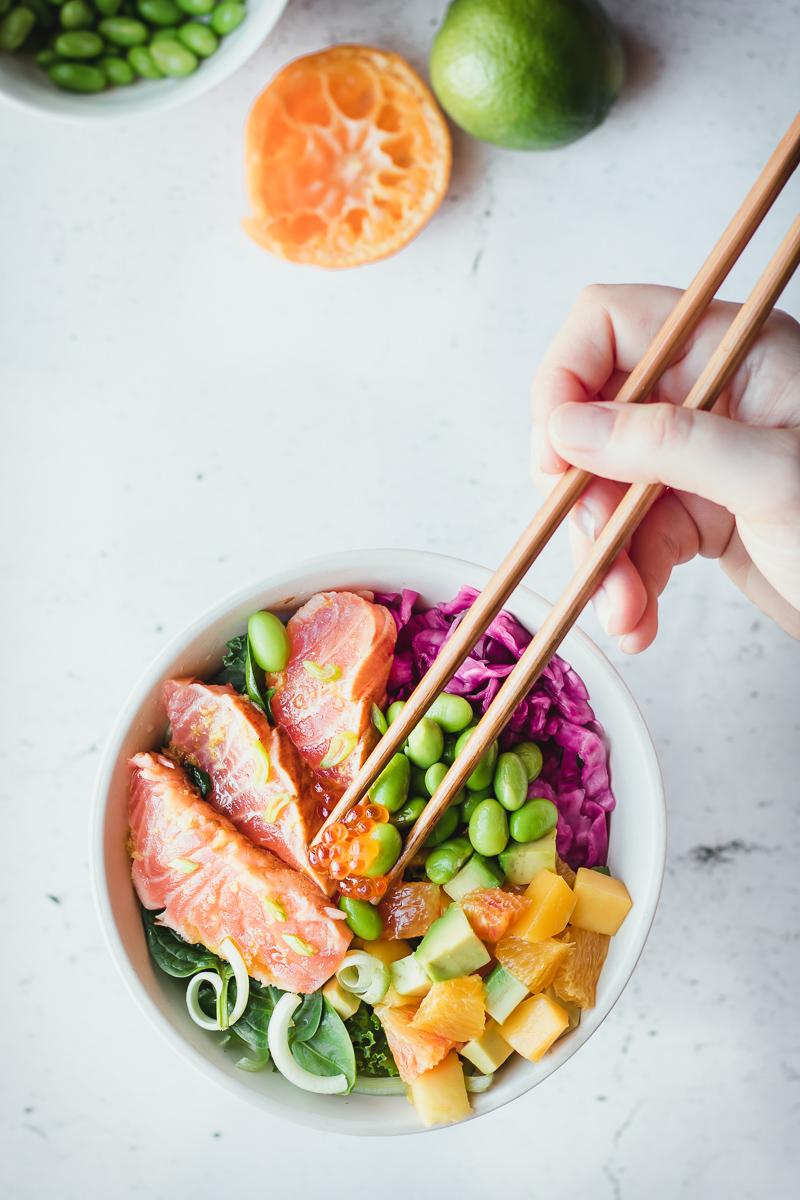 Bowl low carb di salmone in salsa ponzu con cavolo cappuccio viola sott'aceto, edamame, verdura e insalata di avocado, mango e arancia
