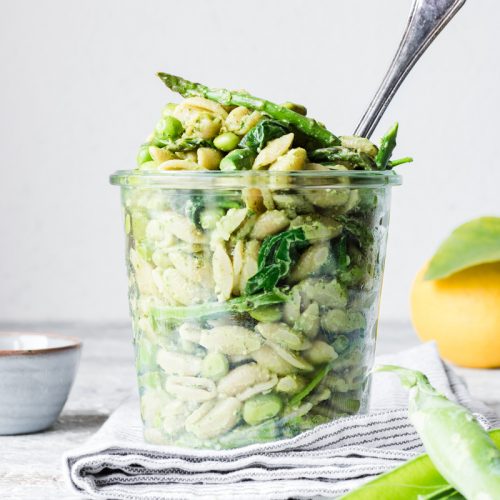 Insalata di pasta con verdure primaverili con pesto al limone in un barattolo perfetta per il picnic di pasquetta