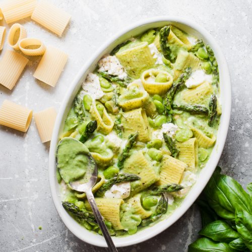 Teglia di pasta al forno vegetariana con asparagi, fave, basilico e burrata pronta per il forno