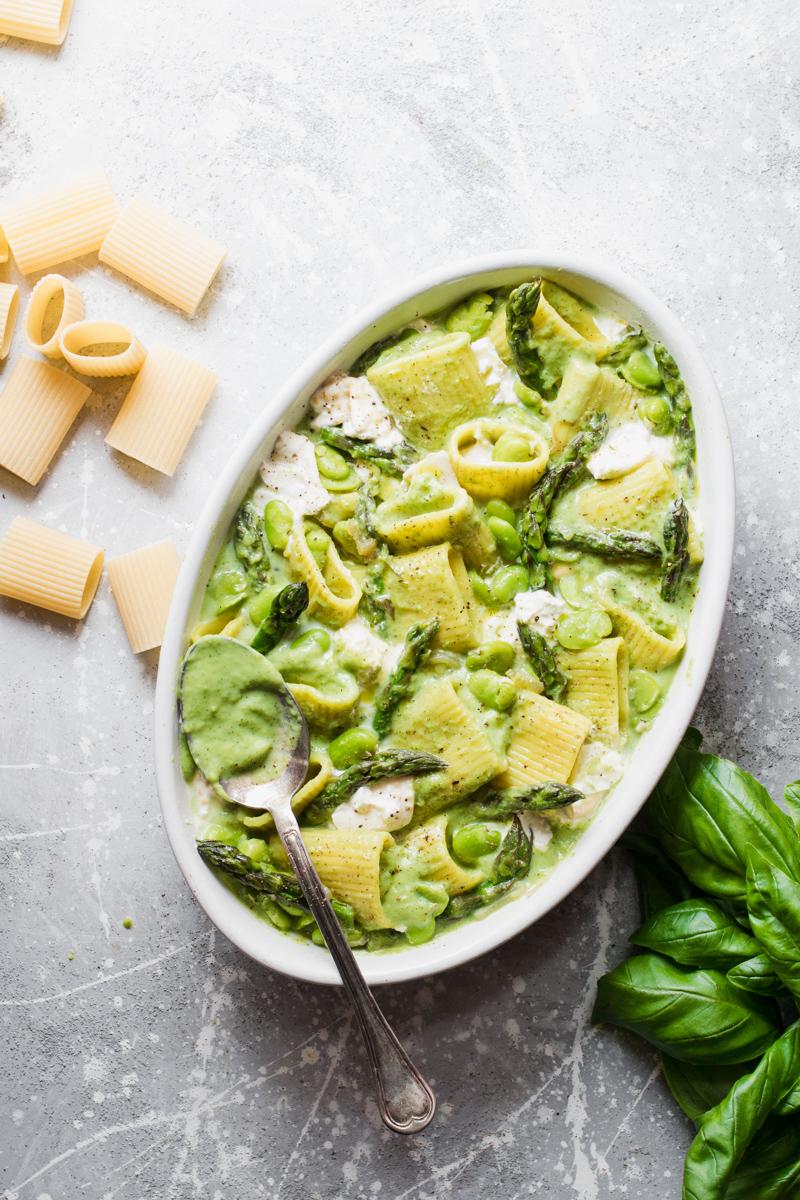 Teglia di pasta al forno vegetariana con asparagi, fave, basilico e burrata pronta per il forno