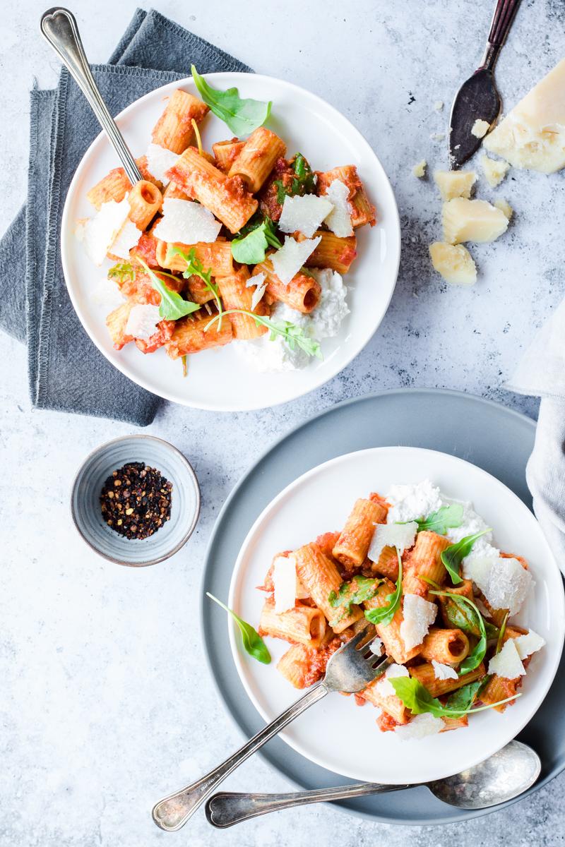 Due piatti di rigatoni all'amatriciana ma senza guanciale nè pancetta, con rucola, pomodorini, ricotta e parmigiano 