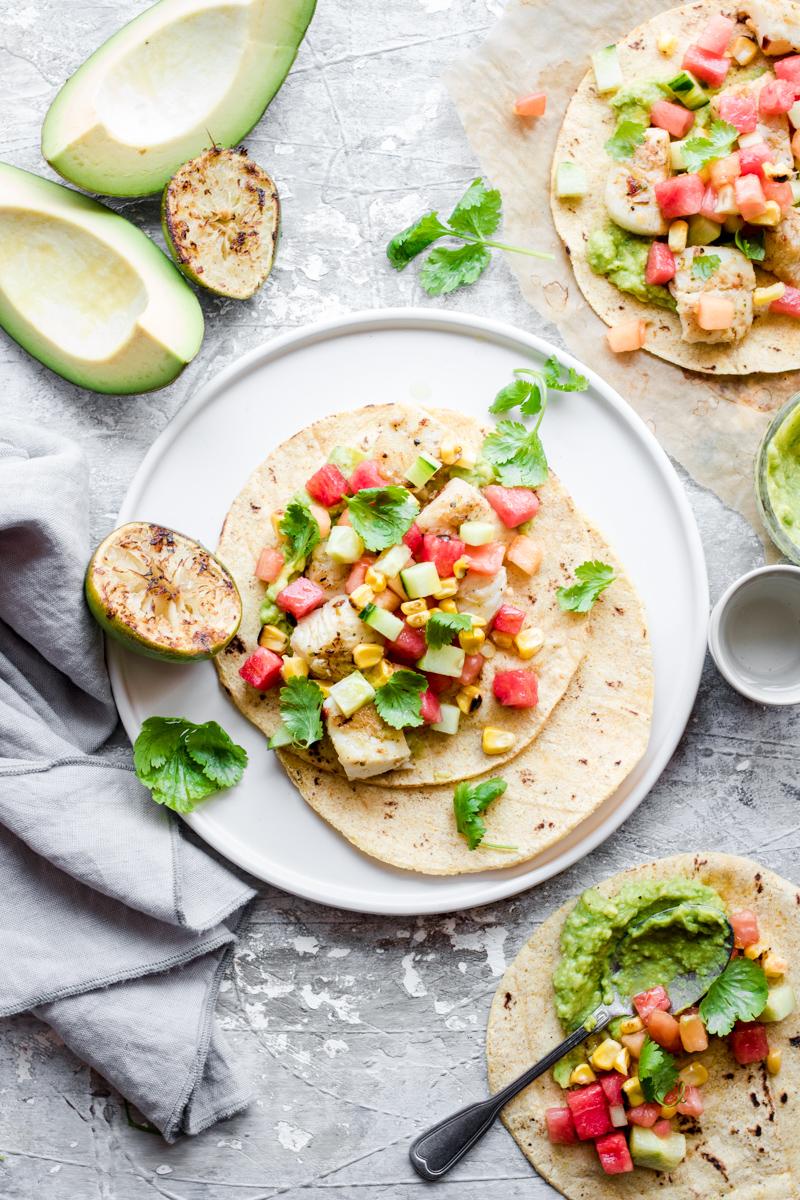 Taco di halibut aperto con salsa, foglie di coriandolo e lime spremuto