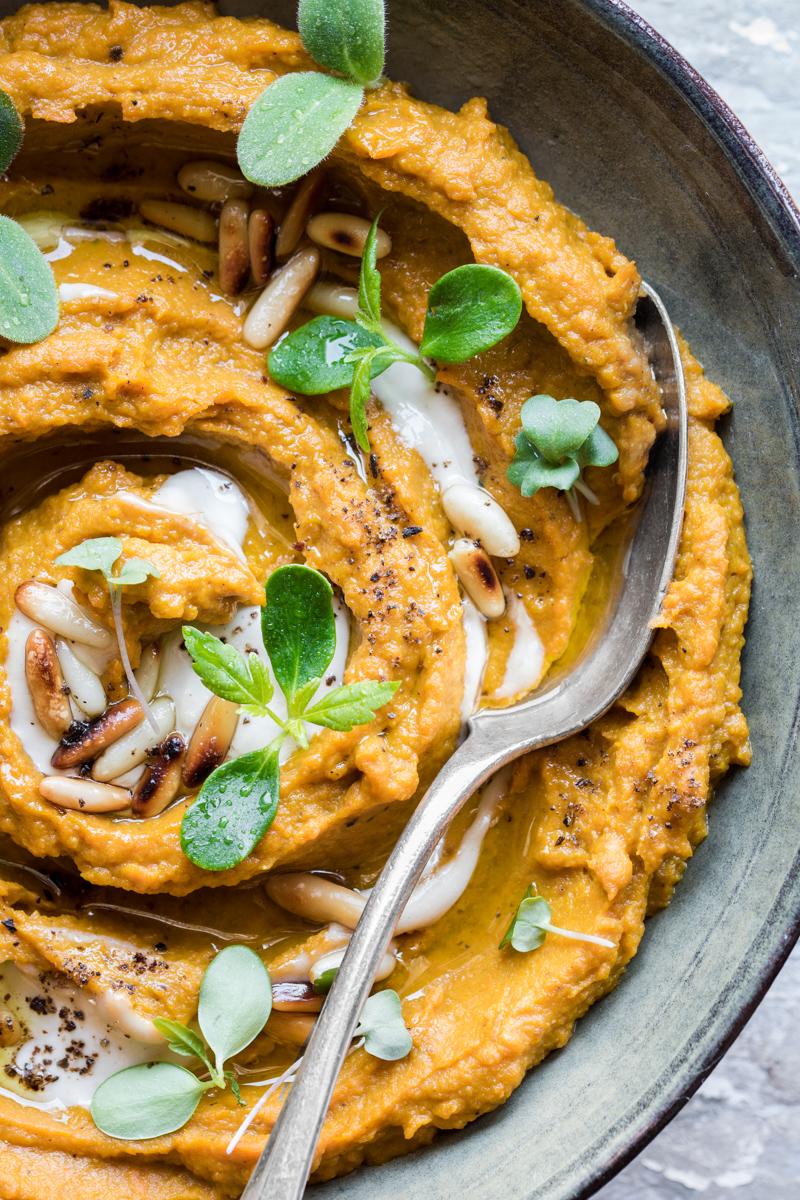 close up di hummus di zucca e carote al miso con tahine e pinoli