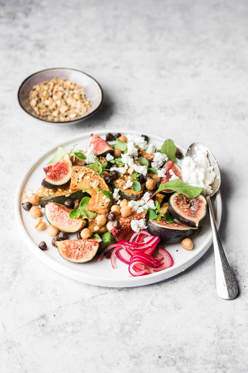 Piatto con Insalata di fichi con zucca alla dukkah e ceci, barattolo con cipolle sott'aceto e cucchiaio di ricotta