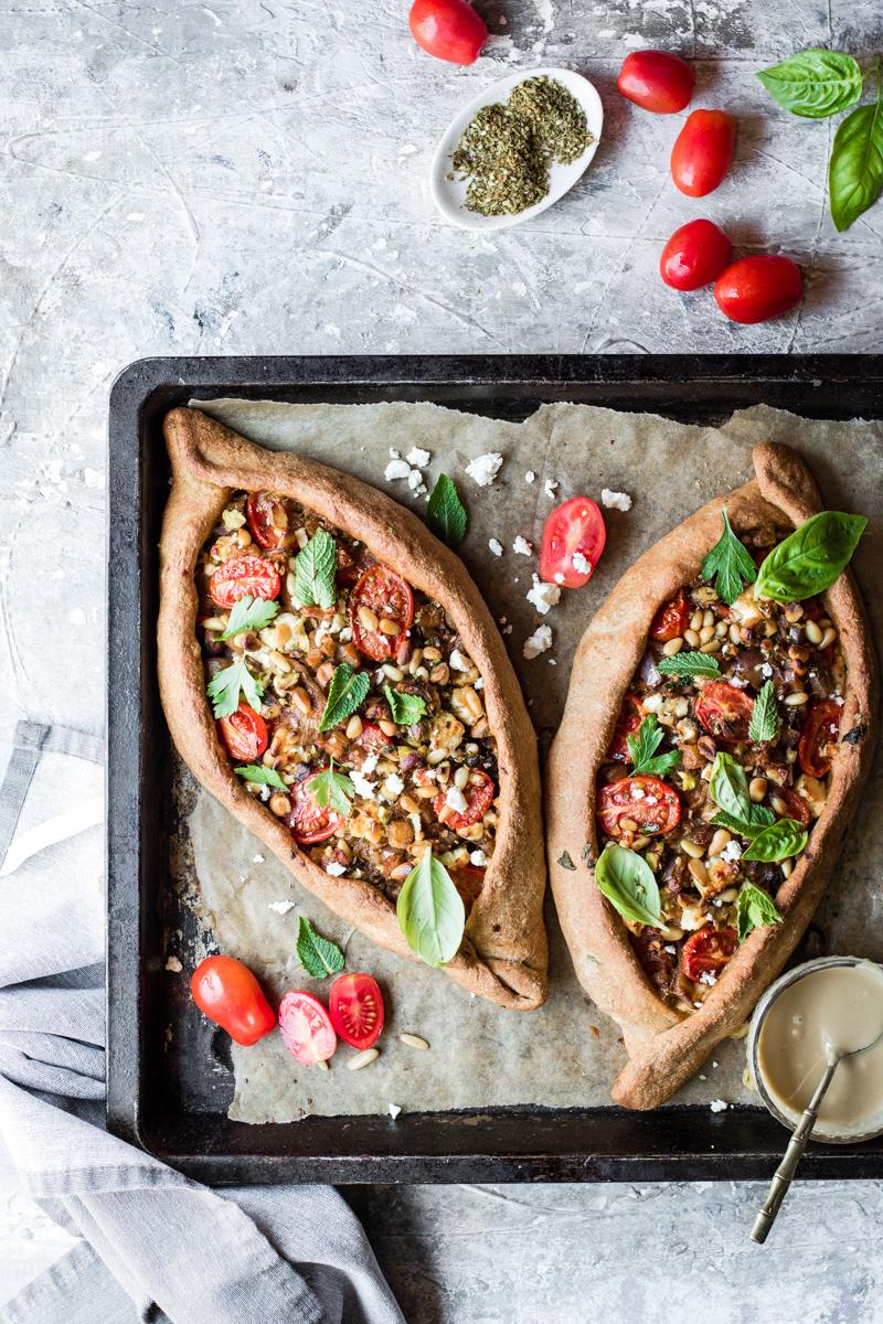 Teglia da forno con due turkish pide con pomodorini, feta e erbe aromatiche