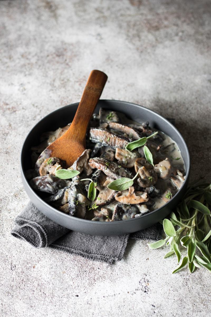 Ciotola con funghi cremosi e foglie di salvia 