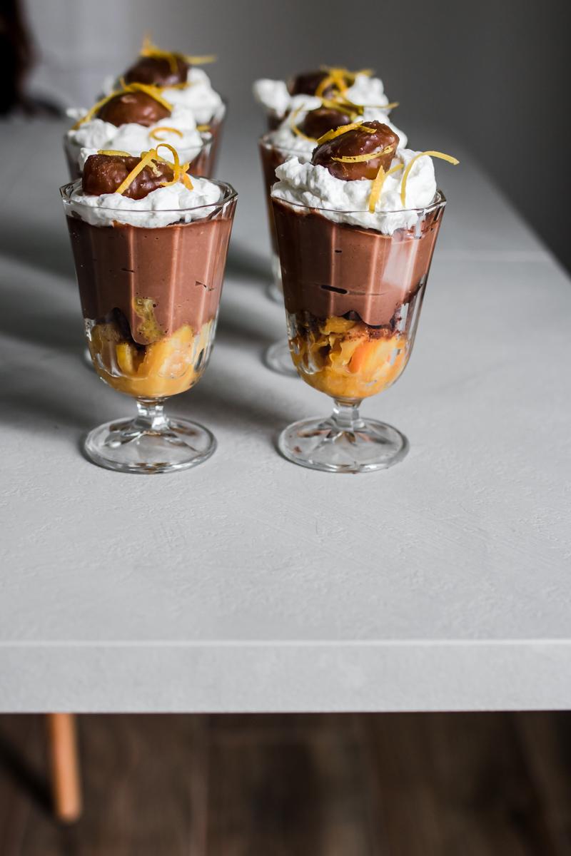 tavolo con sopra coppe con composta di arancia, crema cioccolato e castagne e marron glacè