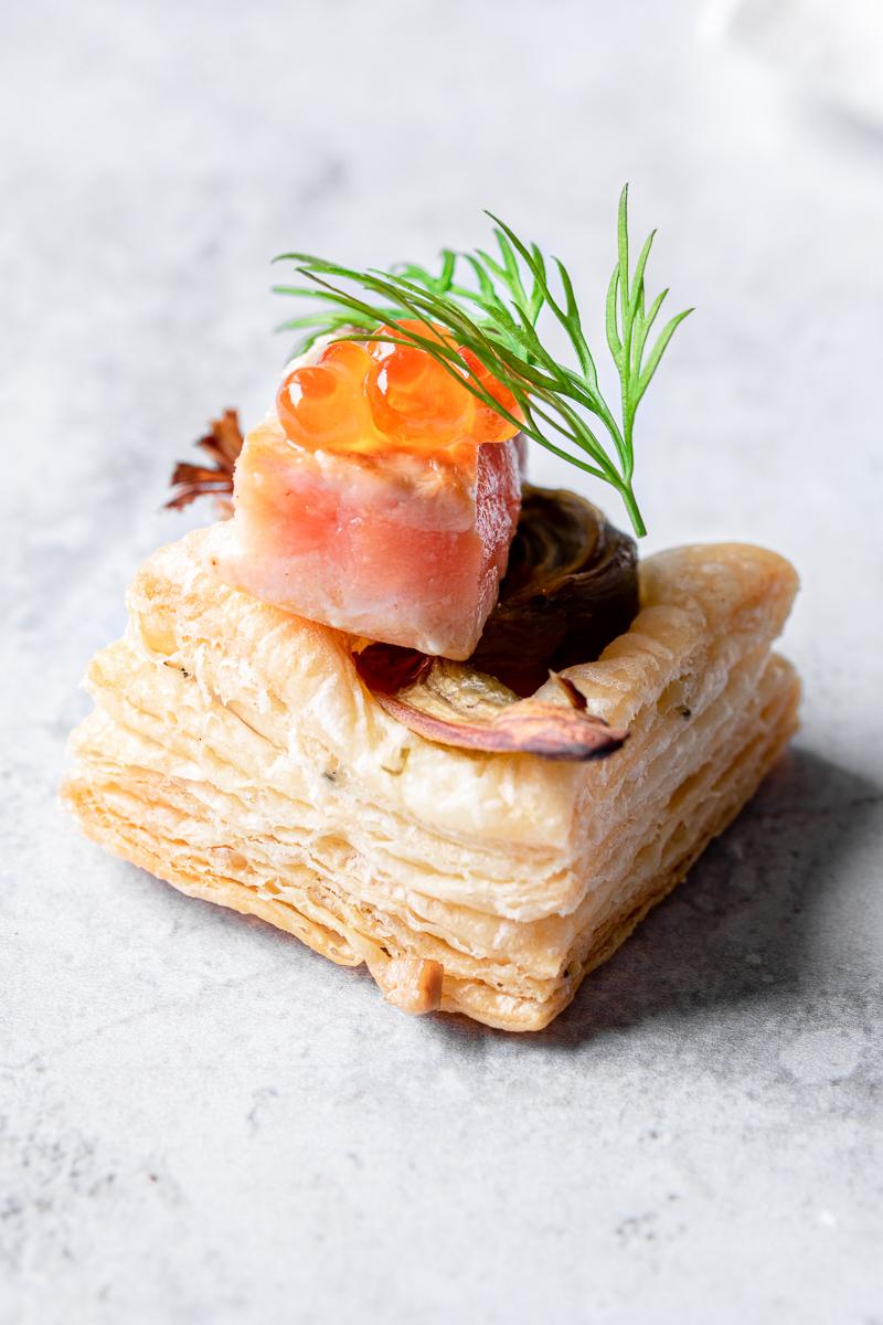 Foto ravvicinata di un salatino di sfoglia furba con salmone, carciofo, roe e aneto