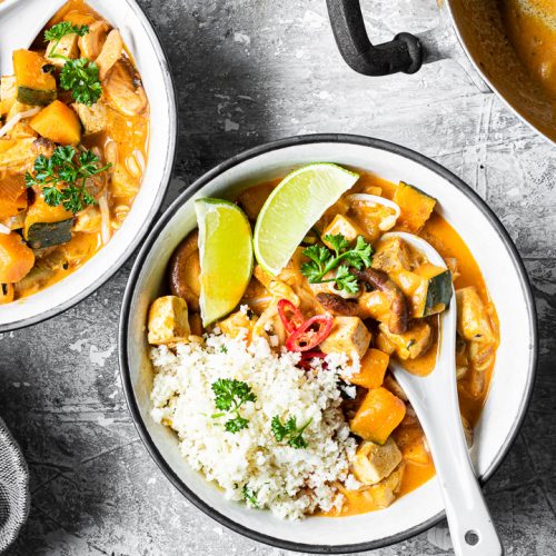 ciotola di red curry vegano low carb con riso di cavolfiore e fettine di lime