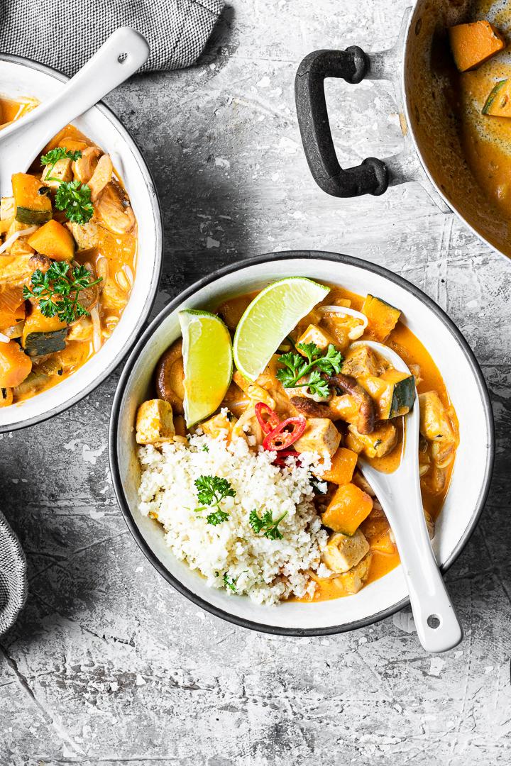 ciotola di red curry vegano low carb con riso di cavolfiore e fettine di lime