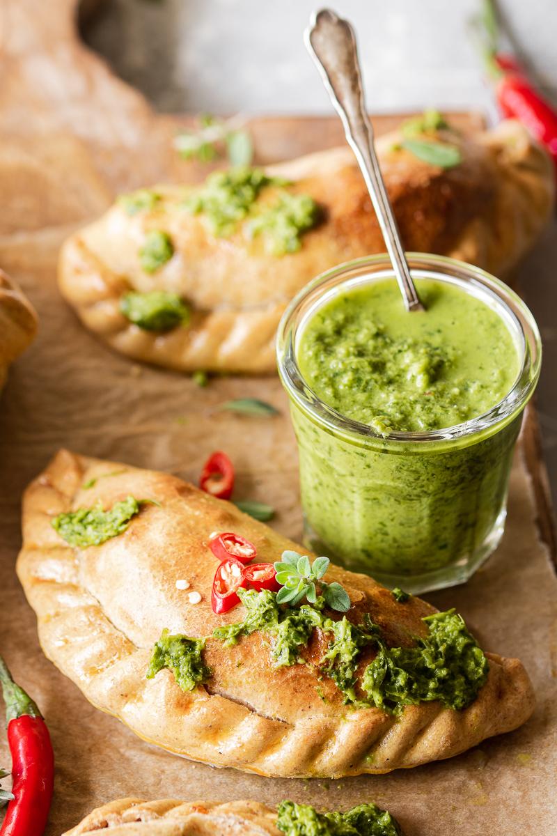 Empanadas vegetaiane al forno con bicchiere di salsa chimichurri