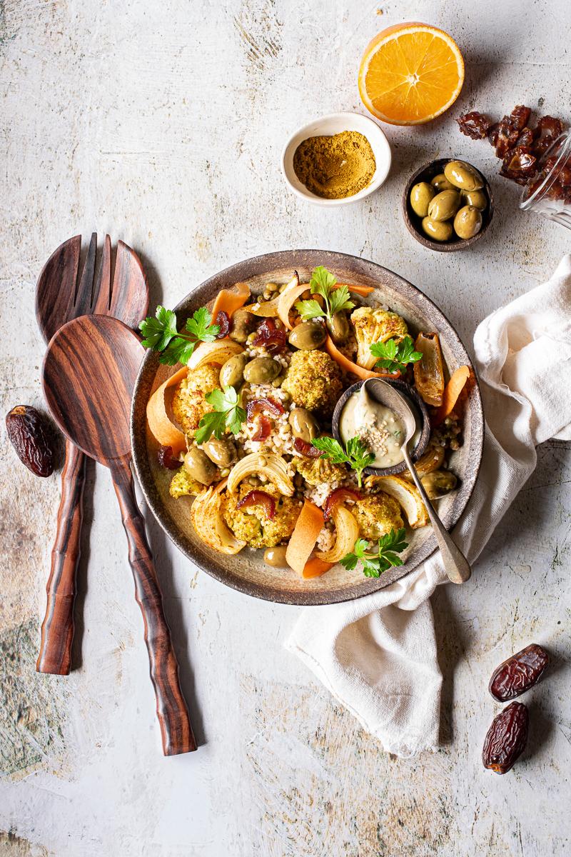 Insalata di cavolfiore arrosto con bulgur, fagioli, datteri e carote in una ciotola