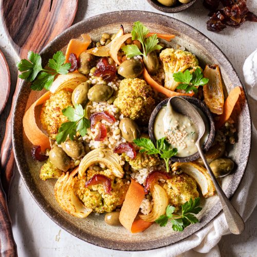 Insalata di cavolfiore arrosto con bulgur, fagioli, datteri e carote in una ciotola