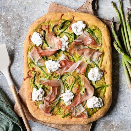 pizza bianca in teglia con burrata, asparagi, speck e crema di piselli