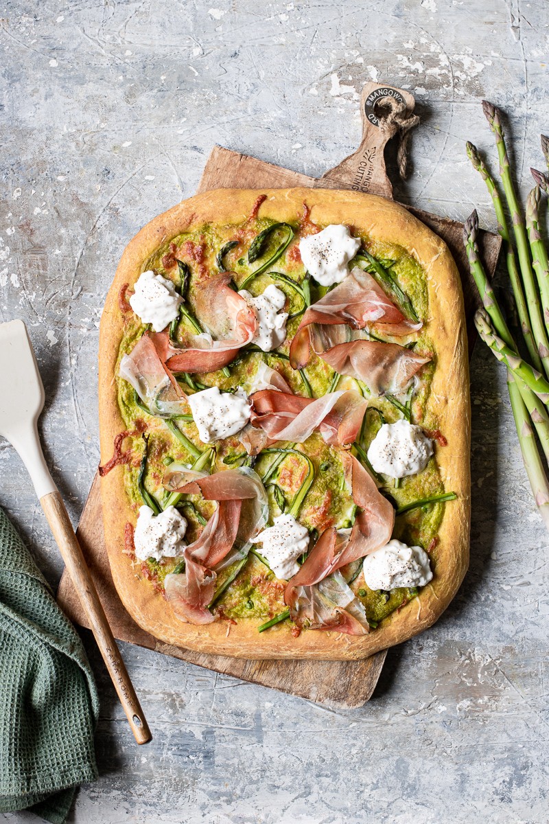 pizza bianca in teglia con burrata, asparagi, speck e crema di piselli