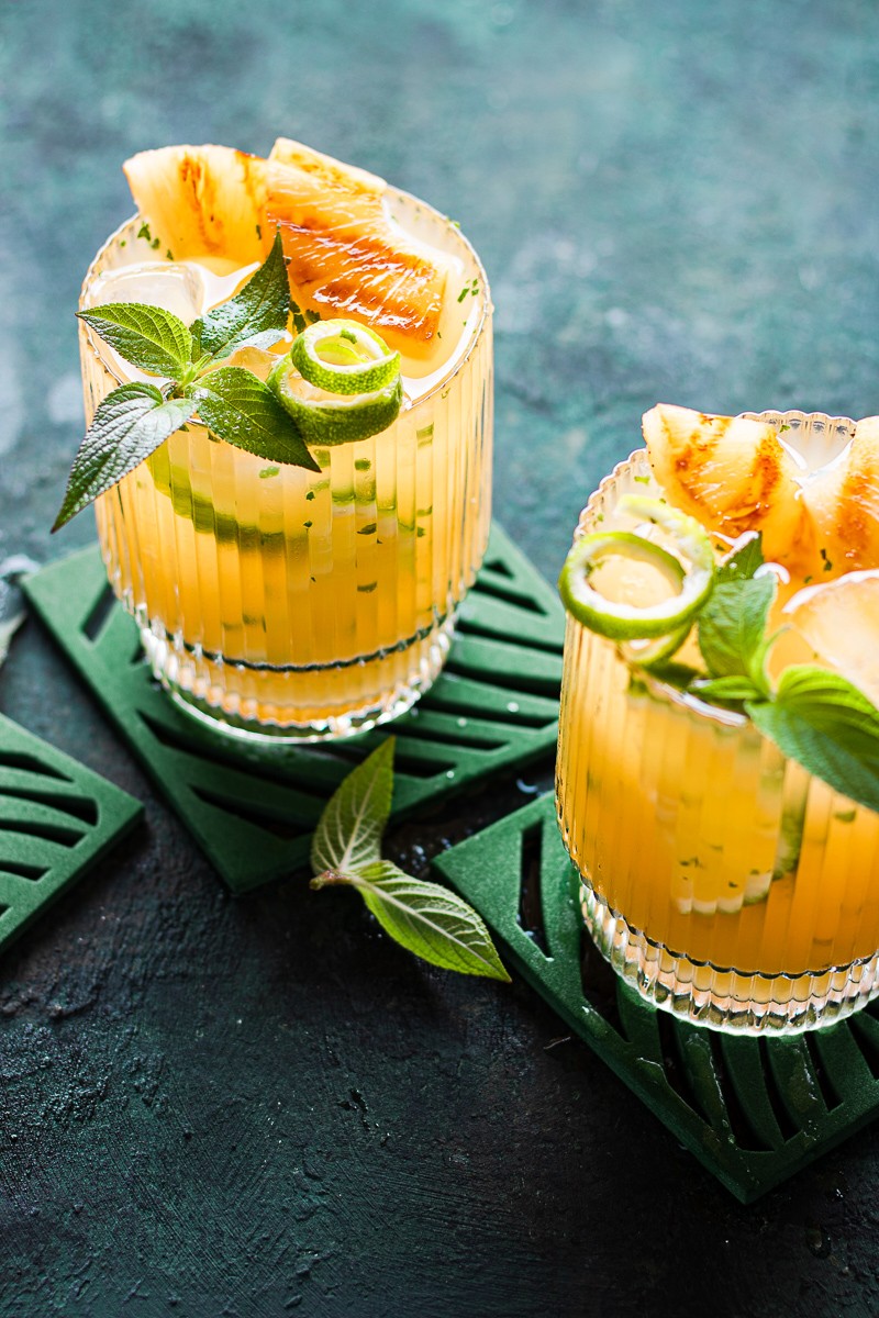 due bicchieri contenti un cocktail all'ananas tipo paloma