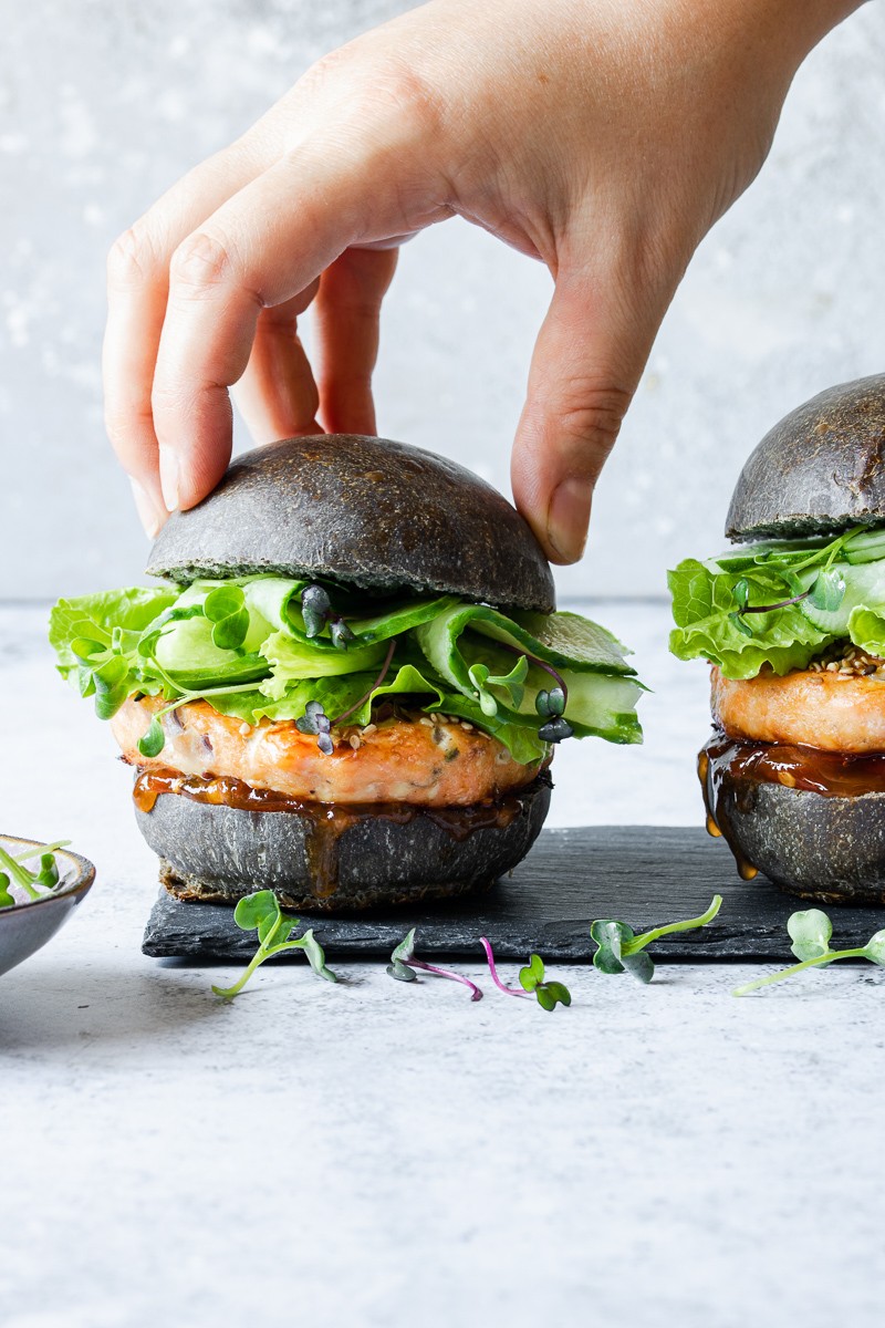 Hamburger di salmone con bun al nero di seppia, cetrioli e salsa senapata