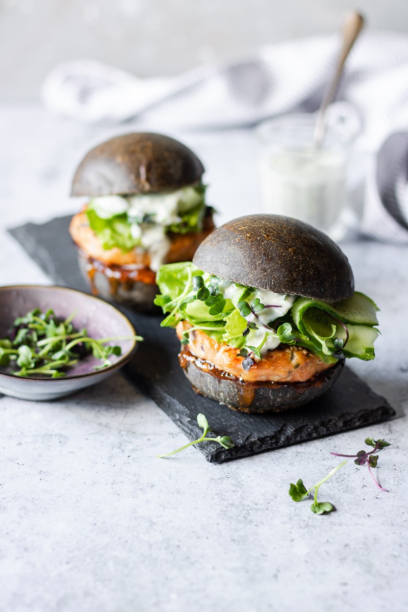 Hamburger di salmone con bun al nero di seppia, cetrioli e salsa allo yogurt