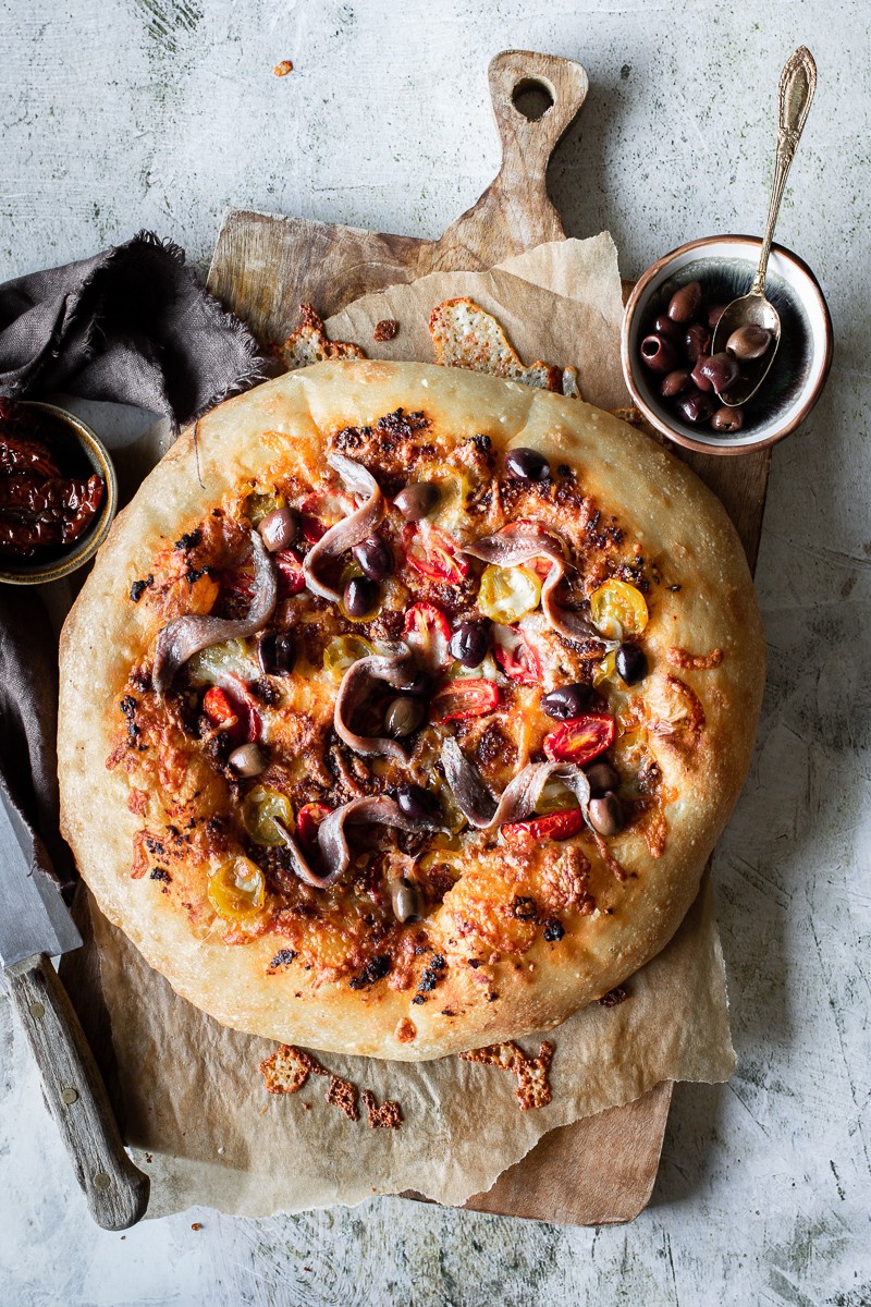 pizza con acciughe pesto di pomodorini e olive