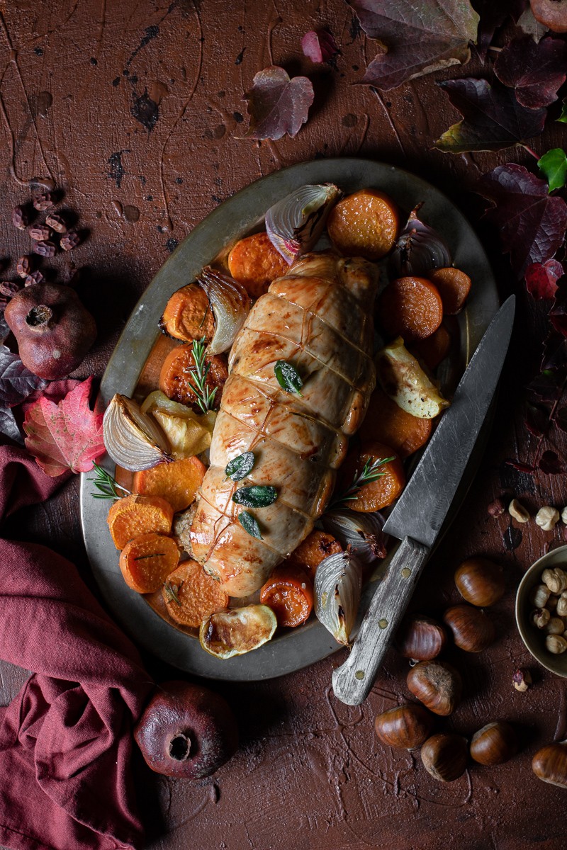 arrosto di tacchino ripieno su vassoio d'argento con contorno di patate mele e cipolle