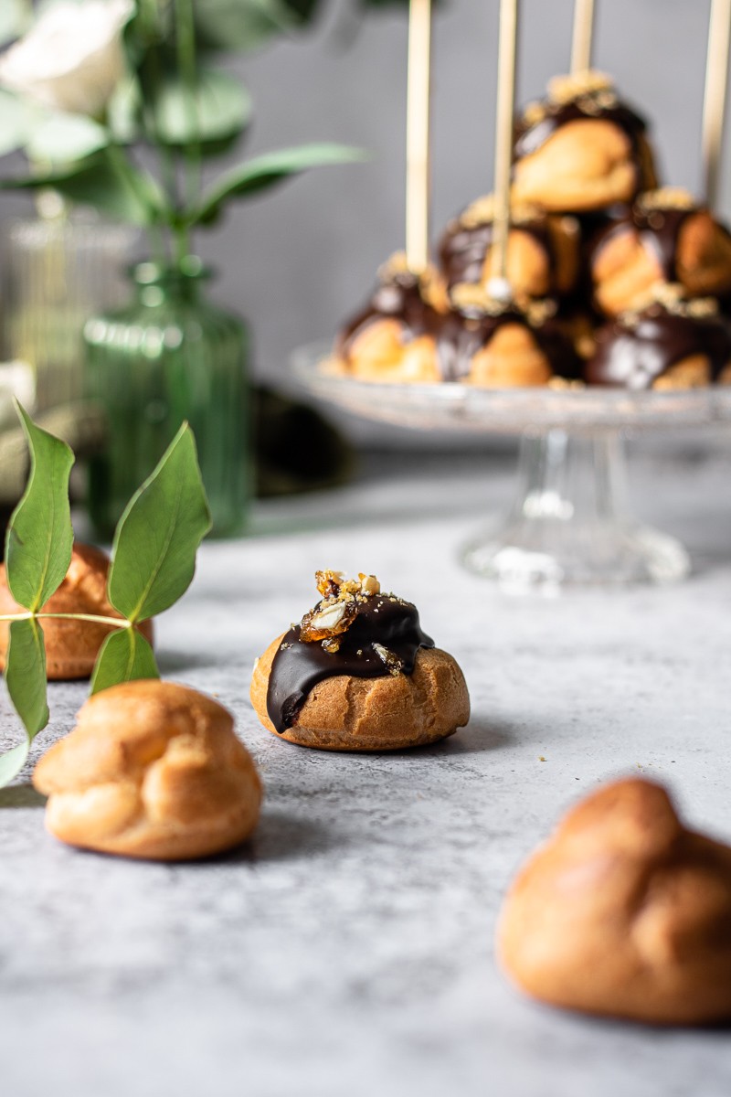 Profiterole al cioccolato ripieno di crema mousseline al pralinato