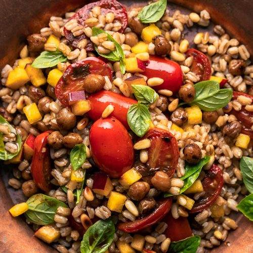 insalata di farro vegana con pomodori aglio nero pesca